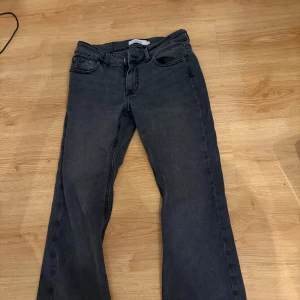 Mörkgrå jeans med raka ben - Snygga mörkgrå jeans med klassisk femficksdesign och raka ben. Jeansen har en enkel look med svarta sömmar och bälteshällor. Perfekta för dig som gillar en stilren och avslappnad vibe. Är i bootcut storlek S från Junkyard.