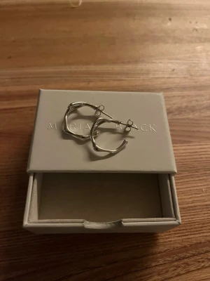 Örhängen i silver Maria Black - Oanvända örhängen i silver från Maria Black. Örhängena är ett höger och ett vänster ca innerdiameter 18mm. Säljes vanligtvis styckvis.