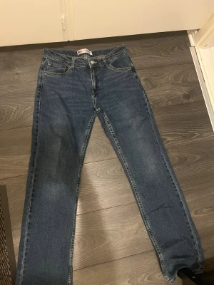 Levi's 551Z Straight blå jeans - Snygga Levi's 551Z Authentic Straight jeans i klassisk blå tvätt. Modellen har raka ben, fem fickor och gul kontrastsöm. W30 L32, gör gärna av sig vid mina lilla fundering