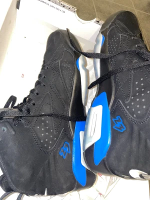 Nike Jordan MVP svart/blå sneakers - Säljer ett par Nike Jordan MVP sneakers i svart mocka med blå och grå detaljer. Skorna har högt skaft, snörning och tydlig Jumpman-logga samt 23-brodyr på sidan. Snygg design med coola kontraster och signaturen 'Flight' på plösen. Perfekta för dig som gillar streetwear.