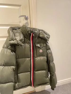 Moncler Montbeliard jacka - Hej, dags att sälja min Moncler Montbeliard jacka. Garanterad äkthet. Äkthetsveriferad av ett företag. Finns även bevis på detta. Storlek 3 vilket motsvarar L. Passar bra på mig som är 190cm. Jackan vart precis inlämnad på kemtvätt vilket kostade mig 400kr, även de tre laglaglapparna (nedre bröst & arm) kostade mig 500kr. Skulle du ha någon fundering får du göra höra av dig. /SR