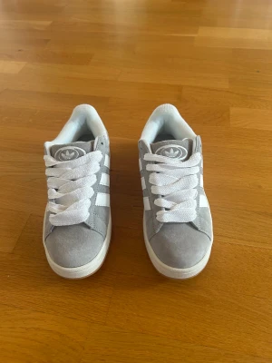 Adidas Campus 00s Grå - Säljer ett par Adidas Campus 00s i grått och vitt, storlek 38. Använda endast en gång så de är i princip i nyskick, inga skador eller fläckar. De är normala i storleken och funkar perfekt både till vinter och höst. Kartong finns, men den är lite sliten. Nypris ca 1 400 kr.