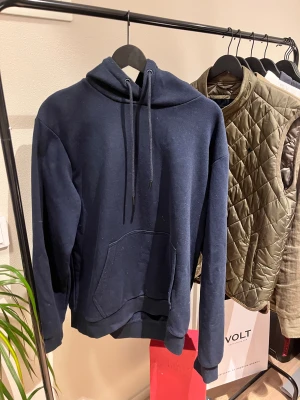 Marinblå hoodie  - Säljer nu denna hoodien i storlek L men passar M. Den är i välldigt bra skick, säljer pga garderobsrensning. Inköpt för någon månad sedan men sparsamt använd 189kr. Priset ej hugget i sten✅😊