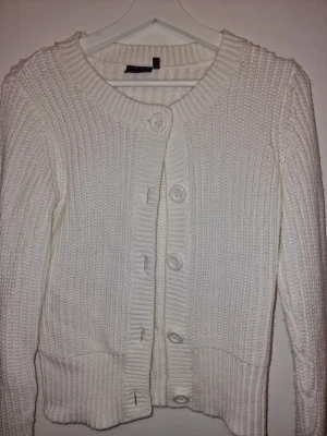 Vit stickad kofta från KappAhl - Snygg vit stickad kofta från KappAhl med stora knappar. Storlek 170 och passar både S och XS.