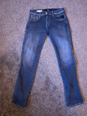 Replay Anbass blå slim jeans - Snygga Replay Anbass jeans i klassisk blå tvätt och snygg fade med slim passform. Bra skick utan några skador, mitt pris: 650 kr, skriv vid minsta fråga⭐️