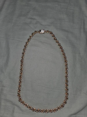 18k gulddoppat halsband från kejsar - Säljer en fet 18K guldlänk med tvinnad design och ett spänne dekorerat med gnistrande stenar. Kedjan har en klassisk rope chain-look och känns riktigt lyxig runt halsen. Perfekt för dig som vill sticka ut med en exklusiv accessoar. 10mm tjockt och 70cm långt.