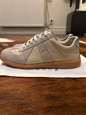 Maison Margiela skor - Säljer dessa feta maison margielas i en schysst beige färg. Dem är i bra skick förutom att det har blivit missfärgat på bakre delen av jeans indigo, men det går att tvätta bort själv med en bra skrubb. 