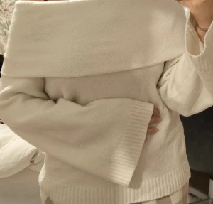 Offshoulder vit stickad tröja Amisu - Superfin vit stickad tröja från Amisu med bred offshoulder-krage och vida ärmar. Tröjan har ribbade detaljer vid ärmslut och nederkant, perfekt för lager-på-lager under kyliga dagar.