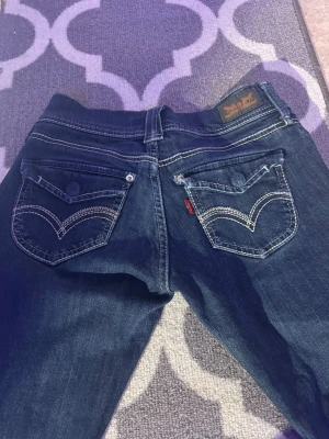 Lowaist mörk blåa jeans - SUPER lowwaist jeans med vita detaljer i okänd storlek. Dessa är en av mina favorit jeans men säljer eftersom de tyvärr blivit för korta, jag är ~ 163 för referens! Skriv ifall du har fler frågor eller funderingar!💕😊