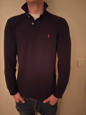 Svart Ralph Lauren piké  - Skit fet Ralph Lauren pike, skön passform, funkar med tisha eller skjorta, Färgen ser skum ut på bilden men den är inte de i person, skriv vid frågor 🔥🔥🔥