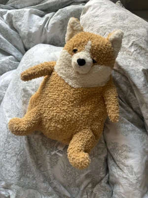 Jellycat beige pälsväst - Säljer en fluffig och mysig beige pälsväst från Jellycat. Västen har en mjuk pälsimitation i beige och vitt, med rundad form och små öron för en gullig look. Perfekt för dig som vill ha något unikt och cozy i garderoben.