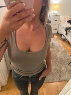 Beige croppad topp med fyrkantig ringning - Säljer en beige croppad topp med fyrkantig ringning och korta ärmar. Toppen har en tight passform och är tillverkad i mjuk bomull som sitter skönt mot kroppen.