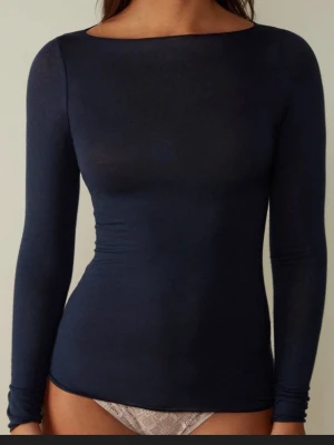Mörkblå intimissmi top!  - Säljer en mörkblå långärmad topp med rundad hals och tight passform. Toppen är enkel och stilren, perfekt att matcha med olika outfits. Materialet känns mjukt och följsamt mot huden. Passar dig som gillar minimalistisk stil och vill ha en topp som sitter snyggt.