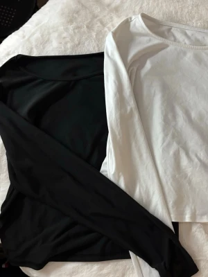 Svart och vit långärmad topp - Två stilrena långärmade toppar i svart och vitt. Säljer båda för de priset ovan.