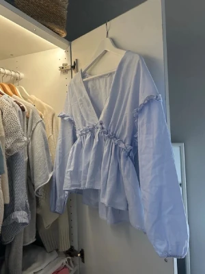 Ljudblå söt blus - Säljer en jättefin ljus blå blus med volanger. Skicket är jättebra🩷