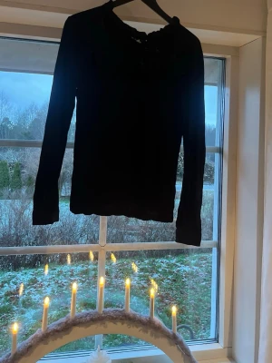 Svart blus med spetsdetalj - Säljer en svart blus med lång ärm och snygg spets upptill vid halsen. Blusen har en rundad hals och är gjord i ett lätt material som ger en skön känsla. Jättesnygg och perfekt till vardags men även finare tillfällen! Jättebra skick också ❤️storlek L men den är väldigt liten i storlek så passar mer S möjligtvis M