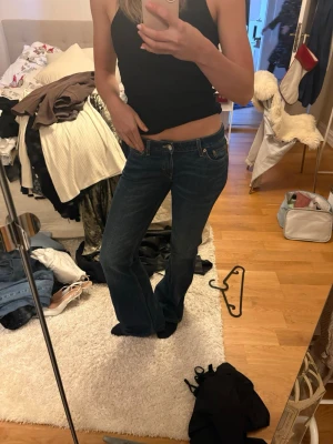 Weekday Nova Low Slim Bootcut Jeans - Säljer ett par mörkblå Weekday Nova Low Slim Bootcut jeans i storlek W27 L34. De har låg midja och klassisk femficksdesign med snygg bootcut passform. Materialet är jeans och de har en stilren look som funkar till många olika outfits.