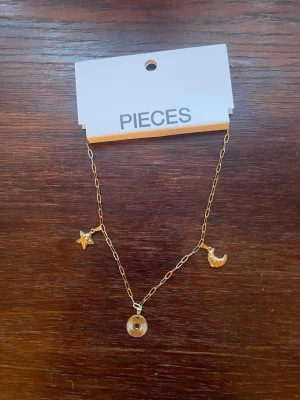 Nytt guldhalsband  - Fint oanvänt guldfärgat halsband beställt från Pieces ❤️Den har tre berlocker, en stjärna, en måne och en ring 