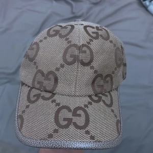 GG JUMBO KEPS - Snygg GG Jumbo keps i klassisk design. Beige/brun färg med stort GG-mönster. Justerbar storlek för perfekt passform. Endast använd ett fåtal gånger och i mycket fint skick.