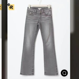 Grå bootcut jeans med fickdetaljer - Snygga grå jeans med bootcut-modell och coola fickdetaljer både fram och bak. Jeansen har klassisk femficksdesign, knapp och dragkedja i gylfen samt lätt slitna kanter nertill. Jeansen är i storlek 170 och är från Gina Young. Inte använd så många gånger.