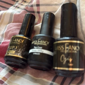 Miss Fancy nagelkit med tre flaskor - Nagelkit med tre flaskor från Miss Fancy Professional: Prep 1 PH Bonder, Top Coat Sheer Milky och Base Coat. Alla flaskor är svarta med guld- och vit text, perfekta för gelnaglar och UV/LED-lampa. Snygg och proffsig look för naglarna.