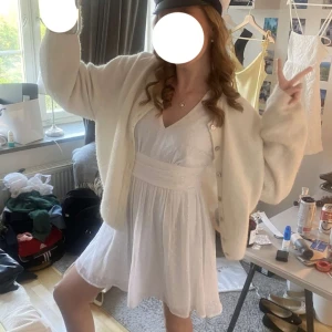 Studentklänning - Superfin vit kortklänning från bubbleroommed diskret prickigt mönster, v-ringning och långa ärmar. Klänningen har knyt i ryggen och markerad midja som ger en snygg siluett. Perfekt till student eller sommarens alla tillfällen! Använd en gång och är i mycket bra skick! Bara att skriva vid frågor! 😊