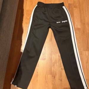Palm Angels byxor - Hej! Säljer nu mina Palm Angels byxor som är i storlek S. Byxorna är i ett mycket bra skick, använt dem bara 2 gånger. Dma mig om du vill ha flera bilder. OBS! PRISET GÅR ATT DISKUTERAS!
