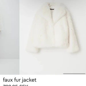 Vit pälsjacka i fuskpäls - Supermjuk och fluffig vit pälsjacka i fuskpäls med bred krage och lång ärm. Jackan har en klassisk rak passform och är perfekt för dig som vill sticka ut med en lyxig vibe. Stängs framtill och har diskreta fickor i sidorna.