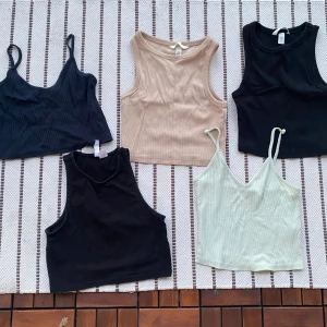 Fem croppade  linnen XS - Fem croppade linnen i olika färger: två svarta, ett beige och ett ljusgrönt. Två av linnena har smala axelband och v-ringning, medan tre har bredare axelband och hög hals/brottartopp. Alla är strlk XS/34. Från h&m och topshop. Säljs tillsammans som ett paketpris. Kommer från hem med katt, katthår förekommer