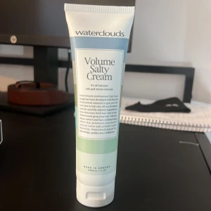 Waterclouds Volume Salty Cream 150ml - Volymgivande saltkräm från Waterclouds i en vit och ljusgrön tub med blå detaljer. Innehåller mineraler från golfströmmen och passar alla hårtyper. Perfekt för att skapa textur och volym i håret. Tuben rymmer 150 ml och är tillverkad i Sverige.