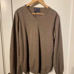 Beige v-ringad stickad tröja Berkeley - Snygg beige stickad tröja från Berkeley med v-ringad hals och ribbade muddar. Tröjan har långa ärmar och coola mockadetaljer på armbågarna. 