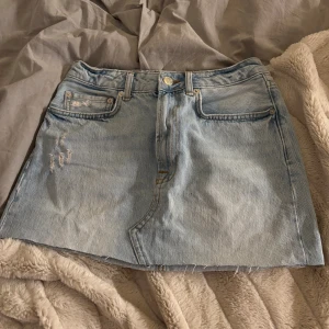 Ljusblå jeanskjol från NA-KD - Snygg ljusblå jeanskjol från NA-KD, sitter superfint på men söker då den tyvärr inte passar längre, superbra skick 