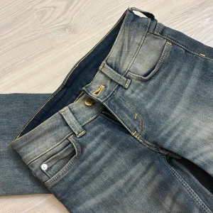 Bootcut jeans från Cheap Monday - Snygga blå bootcut jeans från Cheap Monday med slitna detaljer och klassisk femficksdesign. Jeansen har en ljus tvätt och tydliga kontrastsömmar samt det ikoniska Cheap Monday-märket bak i midjan. Aldrig använt 