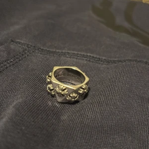Silverring från Chrome Hearts - Säljer en chunky silverring från Chrome Hearts med ikoniska korsdetaljer runt hela ringen. Ringen har en unik kantig form och är tillverkad i massivt silver. Perfekt statement piece för dig som gillar edgy och cool stil. Passar inte mig, storlek 7/ 17mm, skulle tro att de passar någon med storlek 8/9. Pris kan diskuteras!