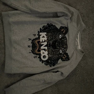 Grå Kenzo sweatshirt med tigertryck XS - Säljer en grå kenzo tröja i storlek xs, tröjan är i nytt skick endast använd ett fåtal gånger. Köpt för 3000 självklart äkta.
