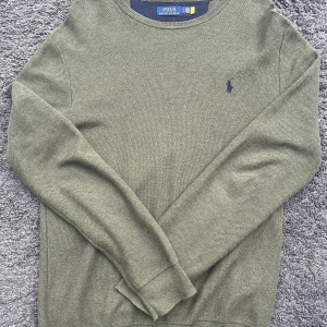 Olivgrön stickad tröja från Polo Ralph Lauren - Klassisk Polo Ralph Lauren stickad tröja i elegant olivgrön nyans. Mycket bra skick/nytt skick.     Använd 1 gång. För stor för mig och därav säljer jag. Nypris: 1500kr. Mitt pris: 599kr. Oroligt snyggt och skönt material och tröja i helhet. Perfekt nu när det börjar bli kyligare! Tröjan är tillverkad i mjukt stickat material. Ett sofistikerat och mångsidigt plagg för dig som gillar tidlös design. Priset är ej hugget i sten! Hör av dig vid minsta tanke eller fundering!😁