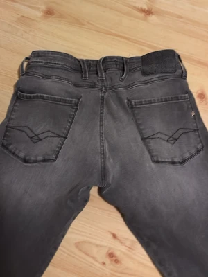 Replay svarta jeans, waist 30/32 - Svarta jeans från Replay med klassisk femficksdesign och snygga detaljer på bakfickorna. Jeansen har rak passform och är tillverkade i slitstarkt denim-material. Perfekt för dig som gillar en enkel och stilren look.