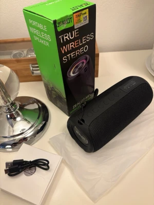 Zealot MP2 Trådlös Högtalare - Zealot MP2 portabel trådlös högtalare med RGB-belysning, USB, TF-kortplats, AUX och Type-C-laddning. Snygg design, tydliga knappar och medföljande laddkabel. Högtalaren är i mycket fint skick utan synligt slitage.