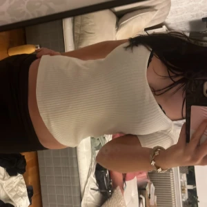 Vit ribbad topp från Gina Tricot - Säljer en vit ribbad topp från Gina Tricot i storlek S. Toppen har korta ärmar, v-ringad hals och är figurnära i modellen. Materialet är mjukt och stretchigt, perfekt för dig som gillar stilrena och enkla plagg. Supersnygg att matcha med jeans eller kjol!