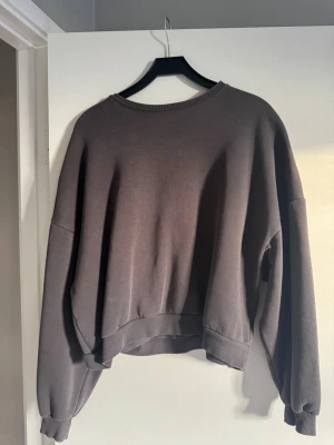 Grå oversized sweatshirt från Nelly - Säljer en grå oversized sweatshirt från Nelly i storlek M. Tröjan har rund hals, ribbade muddar vid ärmslut och nederkant samt långa ärmar. Perfekt för chill dagar och enkel att matcha med jeans eller leggings.