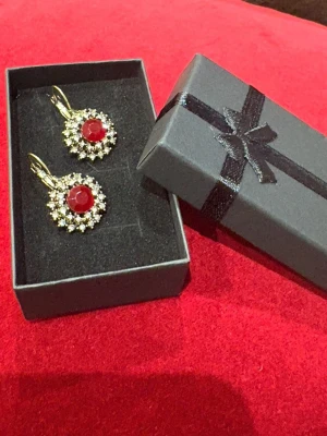 Julklapp 🎄🌹 -  ett par örhängen med röd sten och glittrande detaljer,