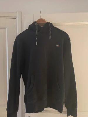 Superdry hoodie - Säljer en superdry hoodie som inte har varit använd utan bara provat en gång. Storlek L. Köpt för ett tag sen men nypris ungefär runt 1000