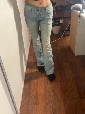 Bootcut ljusblå jeans från Gina - Säljer ett par ljusblå Gina jeans med bootcut-ben. Jeansen har låg midja och är tillverkade i  denim.