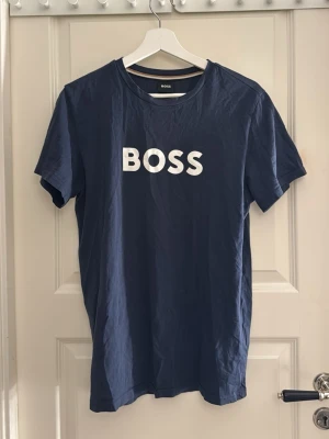 Blå boss t-shirt med tryck  - Mörkblå T-shirt från boss med stort tryck på bröstet. Den är i storlek xs men större i storleken då det är manstorlek. 