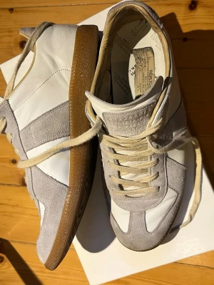 Maison margiela gats vitgrå - Säljer ett par fina Maison margielas gats i bra skick. De är i storlek 43 och har allt og med sig. De har inga hål eller revor eller liknande. Självklart äkta och verifierade av vinted. Allt medkommer hör av er vid frågor🙏