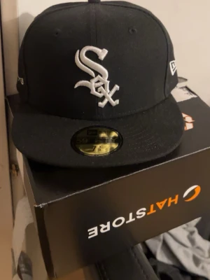 Svart New Era 59FIFTY keps White Sox - köpte då fel storlek (58,7) och går ej att returnera eftersom den är personligt broderad med ”daisy<3” så om någon har en tjej eller liknande som heter daisy är den helt oanvänd (testad). Kartong, stickers följer med. Köpt för 600kr på hatstore. Pris diskuterbart! 