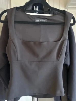 Svart korsett-topp från Zara - Säljer en svart korsett-topp från Zara med breda axelband och fyrkantig urringning. Toppen har en figurnära passform och är tillverkad i ett slätt syntetmaterial som ger en stilren look. Perfekt att styla med jeans eller kjol för en trendig outfit. Storlek L men den är jätte liten i storleken så passar s/m. Säljer en likadan i rosa om man skulle va intresserad av den också🥰