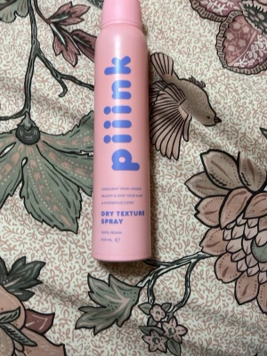 Piink Dry Texture Spray 200ml - Säljer en rosa flaska med Piink Dry Texture Spray, 200 ml. Sprayen är 100% vegansk och kommer i en snygg cylinderformad förpackning med lila text. Perfekt för att ge håret extra volym och textur. Enkel att använda och passar bra i väskan.