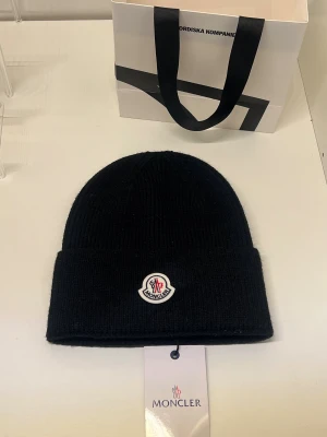 Moncler mössa - Säljer en helt ny moncler mössa. Onesize. Passar dam och herr.Köpta för 2499 kr från NK