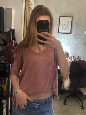 Ljusrosa loose topp med v-ringning - Säljer en mörkrosa topp med v-ringning och lös passform. Toppen har korta ärmar och är tillverkad i ett tunt, mjukt material🥰 